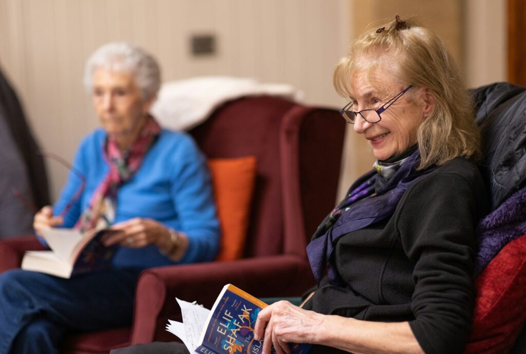 Happy woman reading book at Edmonton Retirement community.